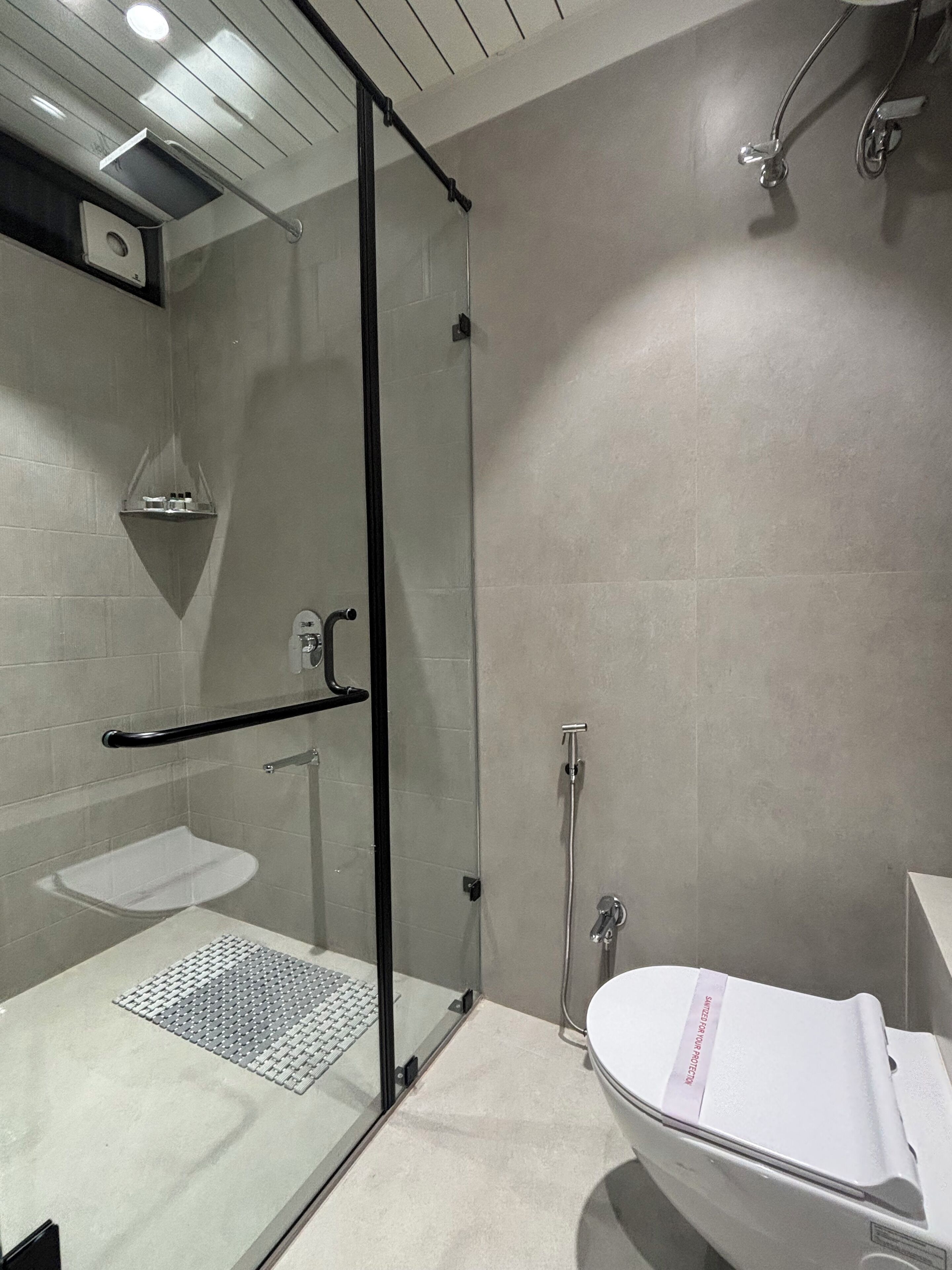 A modern bathroom with a glass shower enclosure, a white sink, and a freestanding bathtub.