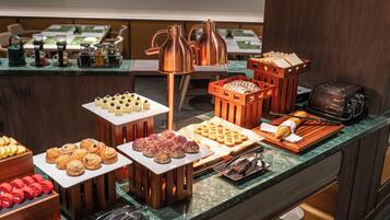 A buffet with various food items and a coffee station.