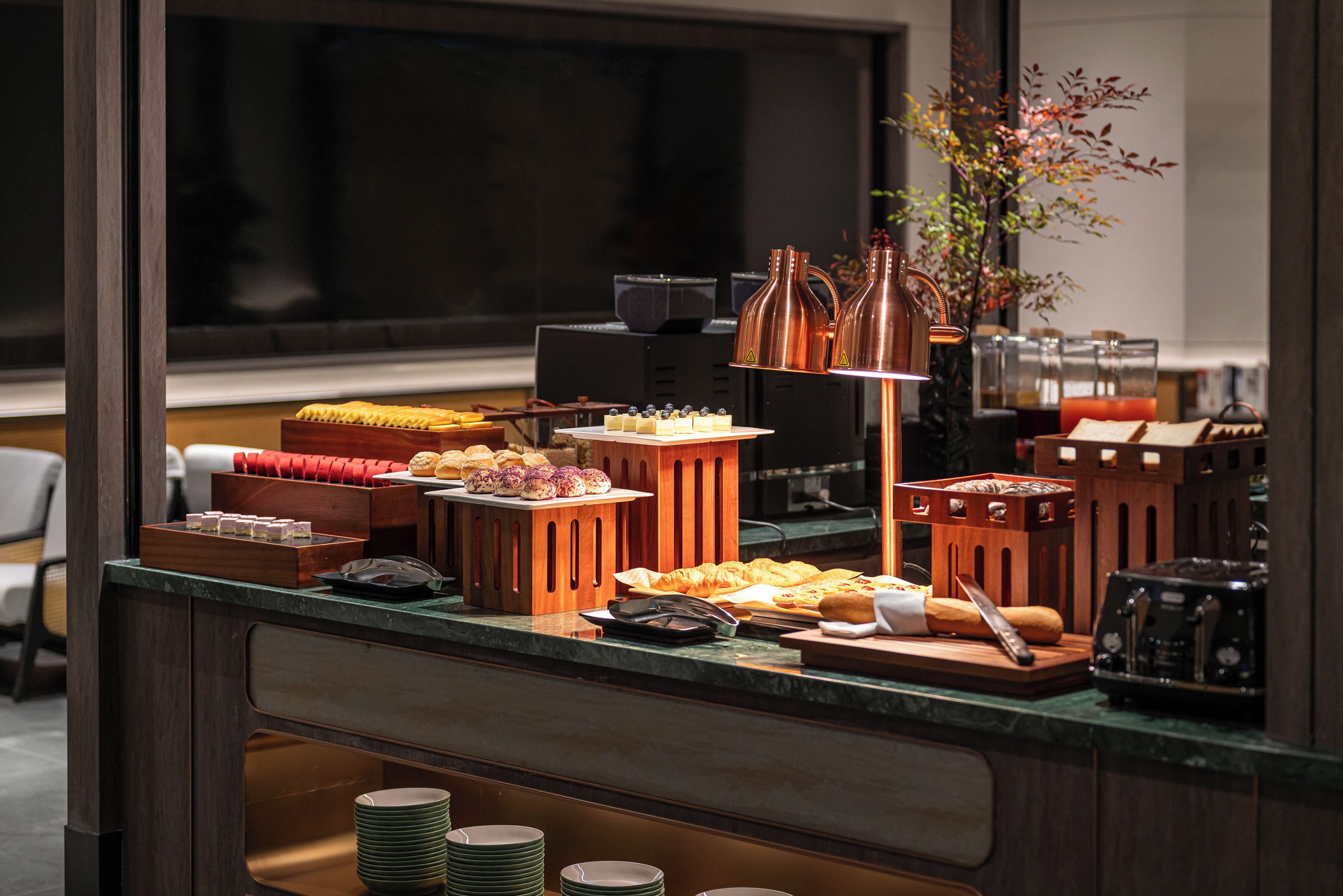A buffet setup with various food items and a coffee machine.