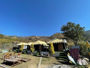 Un terrain de camping avec des tentes et un banc en bois.