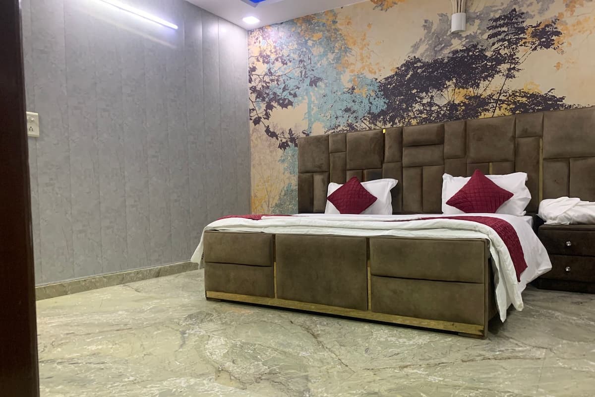 A bedroom with a large bed, a headboard, and a marble floor.