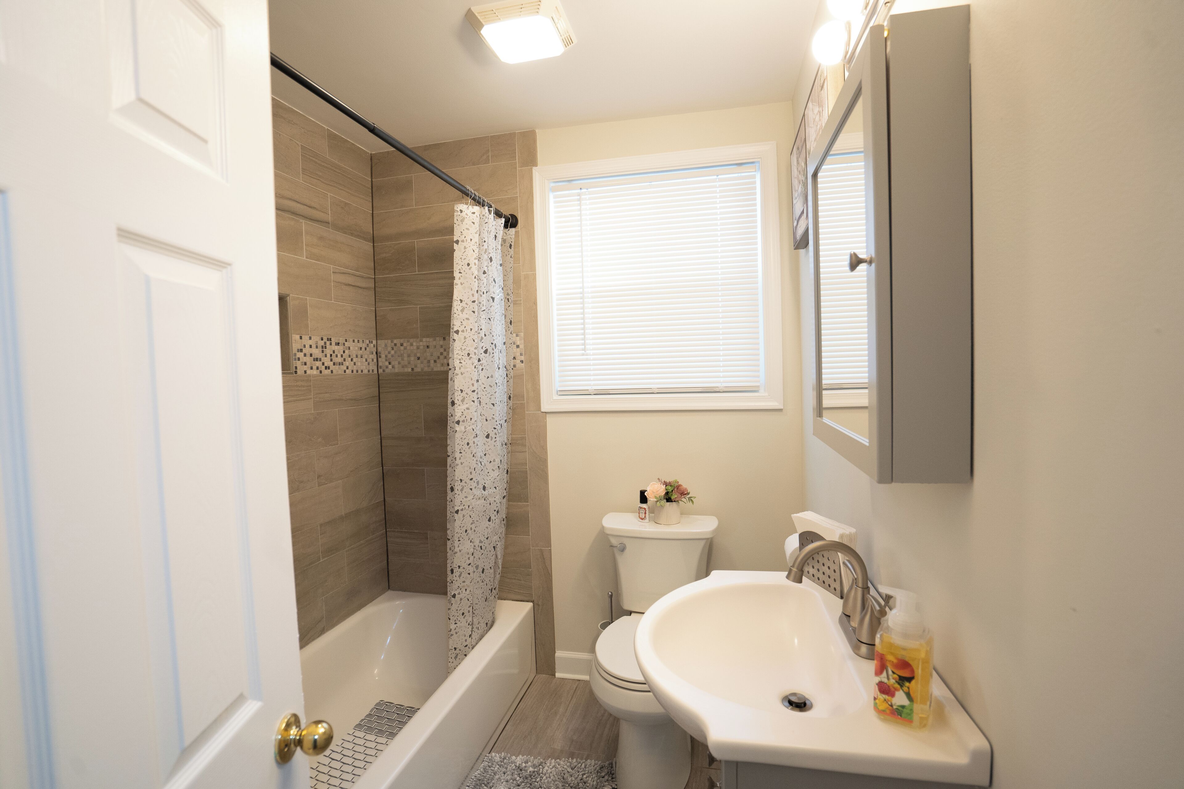 A bathroom with a bathtub, toilet, and sink.