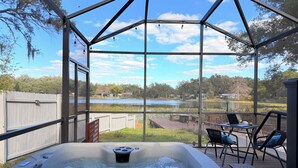 A hot tub with a view of a lake and surrounding trees.