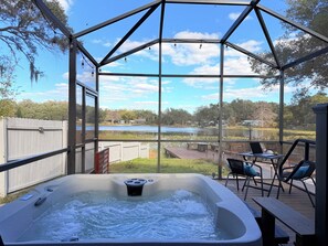 A hot tub with a view of a lake and surrounding trees.