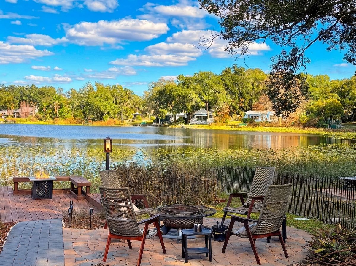 A lakeside patio with outdoor seating and a fire pit.