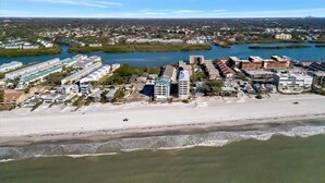 Luftaufnahme einer Küstenlandschaft mit Strand, Gebäuden und einem Fluss.