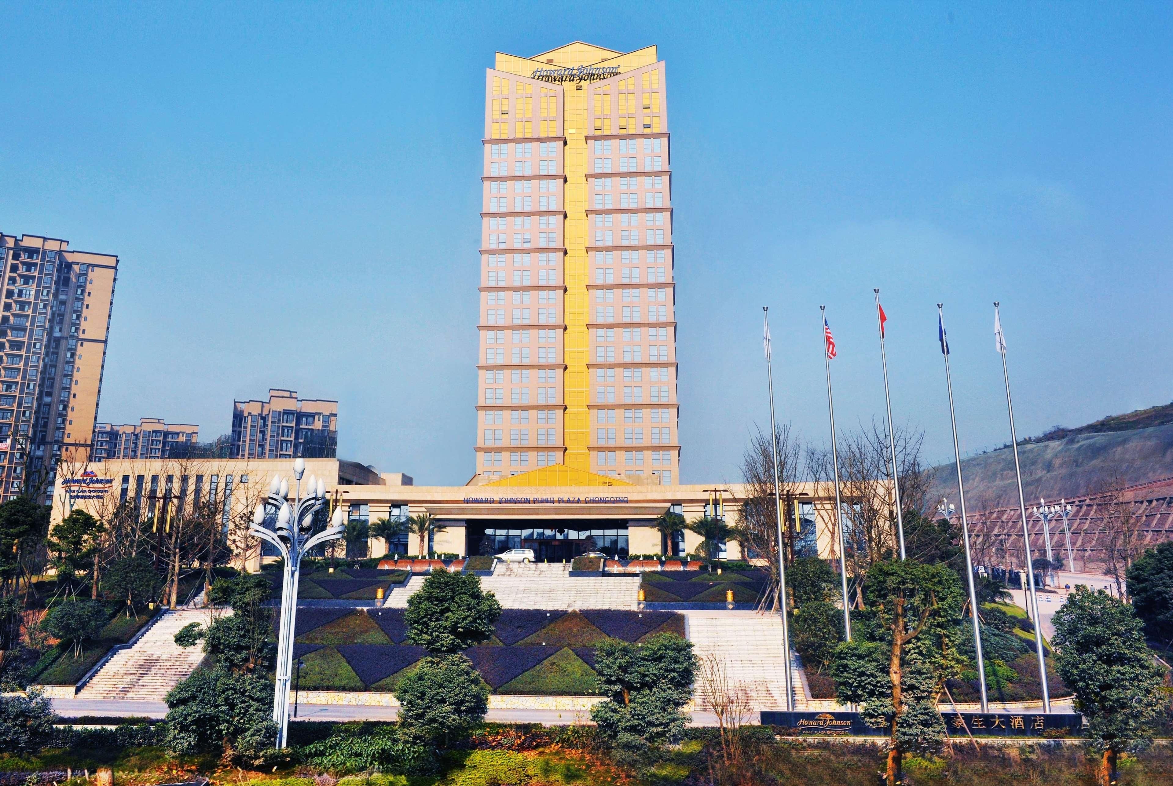 A tall hotel with a yellow facade, multiple floors, and a central entrance.