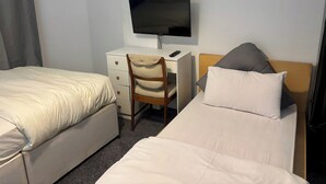 A hotel room with two beds, a desk with a TV, and a chair. - Family Ensuite in Dudley (Dudley)
