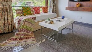 Ein modernes Wohnzimmer mit einer Couch, einem Couchtisch und einem an der Wand montierten Fernseher.