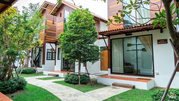 A modern house with a garden, a wooden exterior, and a glass door. - Baanrongmai Canal Front Homestay (Phra Pradaeng)