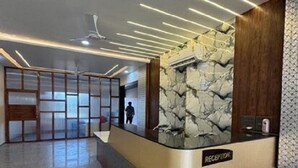 Un espace d’accueil avec un mur en pierre, un comptoir d’accueil et un design moderne au niveau du plafond.