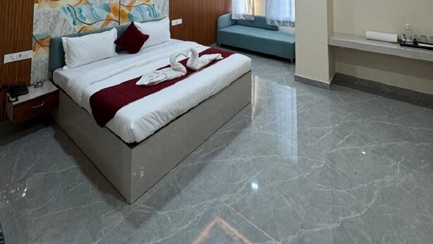 Une chambre moderne avec un grand lit, un ventilateur de plafond et un mur décoré d’œuvres d’art abstraites.
