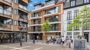 A modern building with multiple floors, large windows, and a mix of brick and glass facades. - Beautiful apartment in the center (Blankenberge)