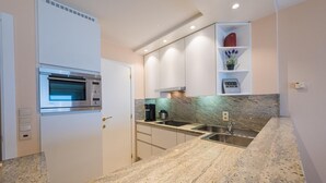 Eine moderne Küche mit Einbauofen, Edelstahlspüle und Granitarbeitsplatten.