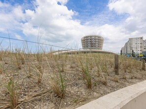 Ein modernes Gebäude mit einem einzigartigen geometrischen Design, umgeben von einer Rasenfläche und einer Betonbarriere.