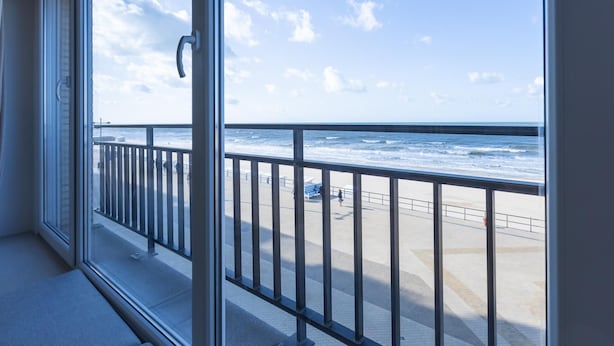 Un balcon avec vue sur l’océan et une plage.