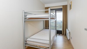 A bunk bed in a hotel room with a view of the city through a window. - Charming apartment near the beach (Middelkerke)