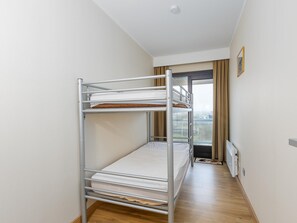 Ein Etagenbett in einem Hotelzimmer mit Blick auf die Stadt durch ein Fenster.