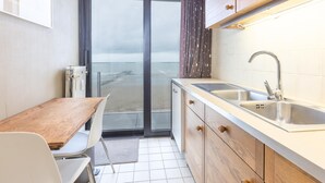 Cozinha moderna com uma janela grande, pia e armários de madeira.