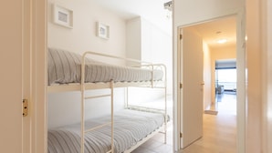 Habitación con literas y una puerta que da a un pasillo.