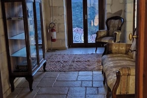 Ein Zimmer mit einem gemusterten Teppich, einem Holzschrank, einem Stuhl und einem Feuerlöscher.