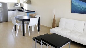 A modern kitchen with white cabinets, a black countertop, and a stainless steel refrigerator. - Dolphin Suites (Willemstad)