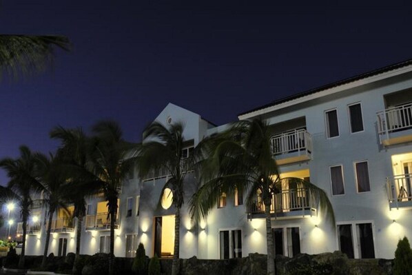 A multi-story hotel with balconies and a well-lit facade at night. - Dolphin Suites (Willemstad)