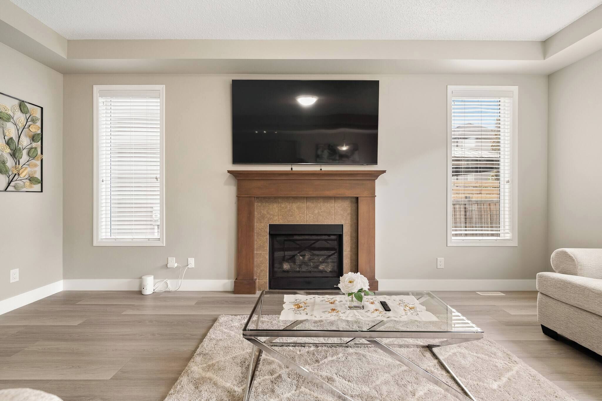 A living room with a fireplace, a flat-screen TV mounted above it, and a sofa.