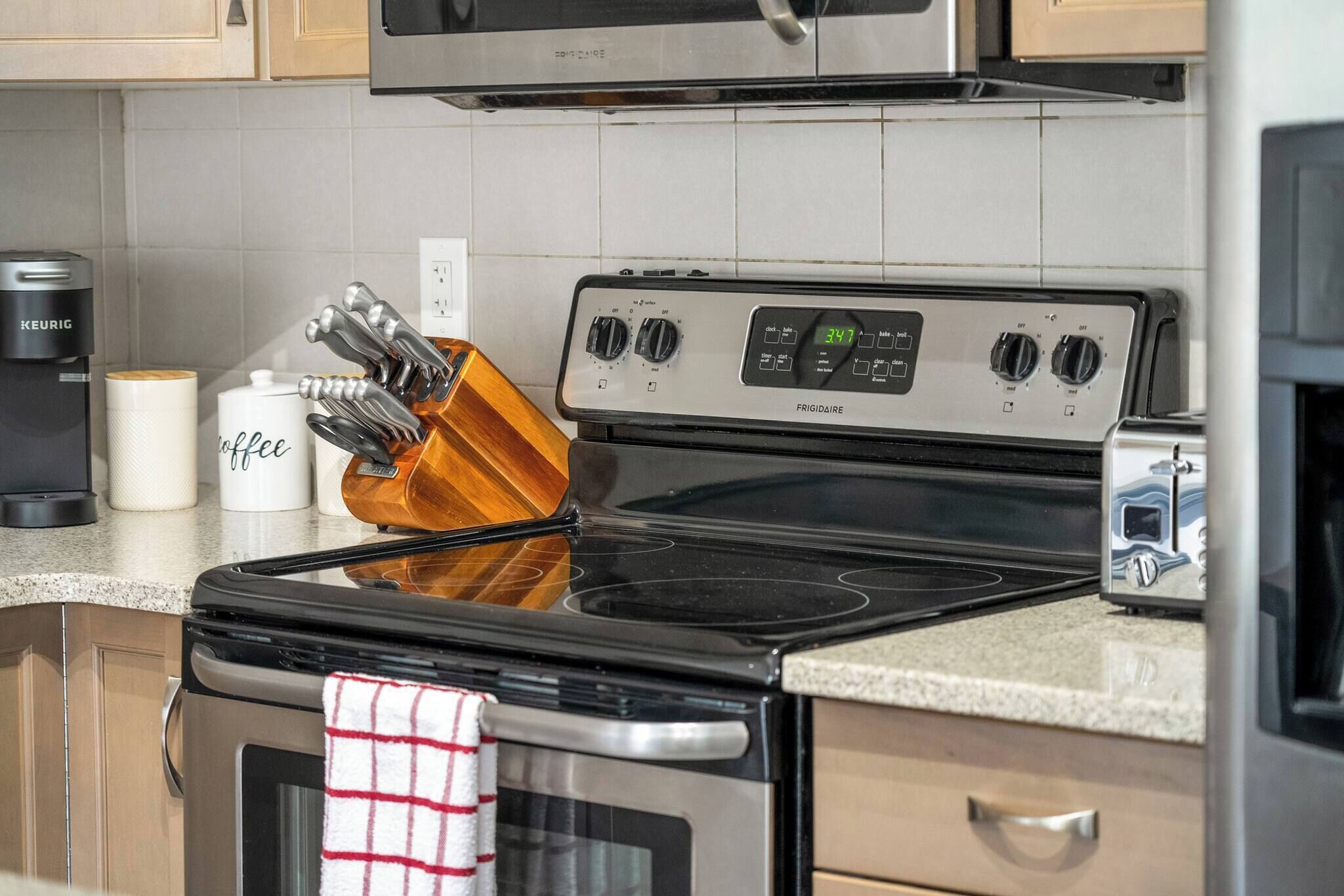 A kitchen with a black stove, a coffee maker, and a toaster.