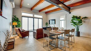 Amplia sala de estar con una mesa de comedor, sillas, un sofá y una televisión.