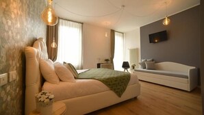 Ein modernes Schlafzimmer mit einem Bett, Nachttisch, Lampe und einer Couch.