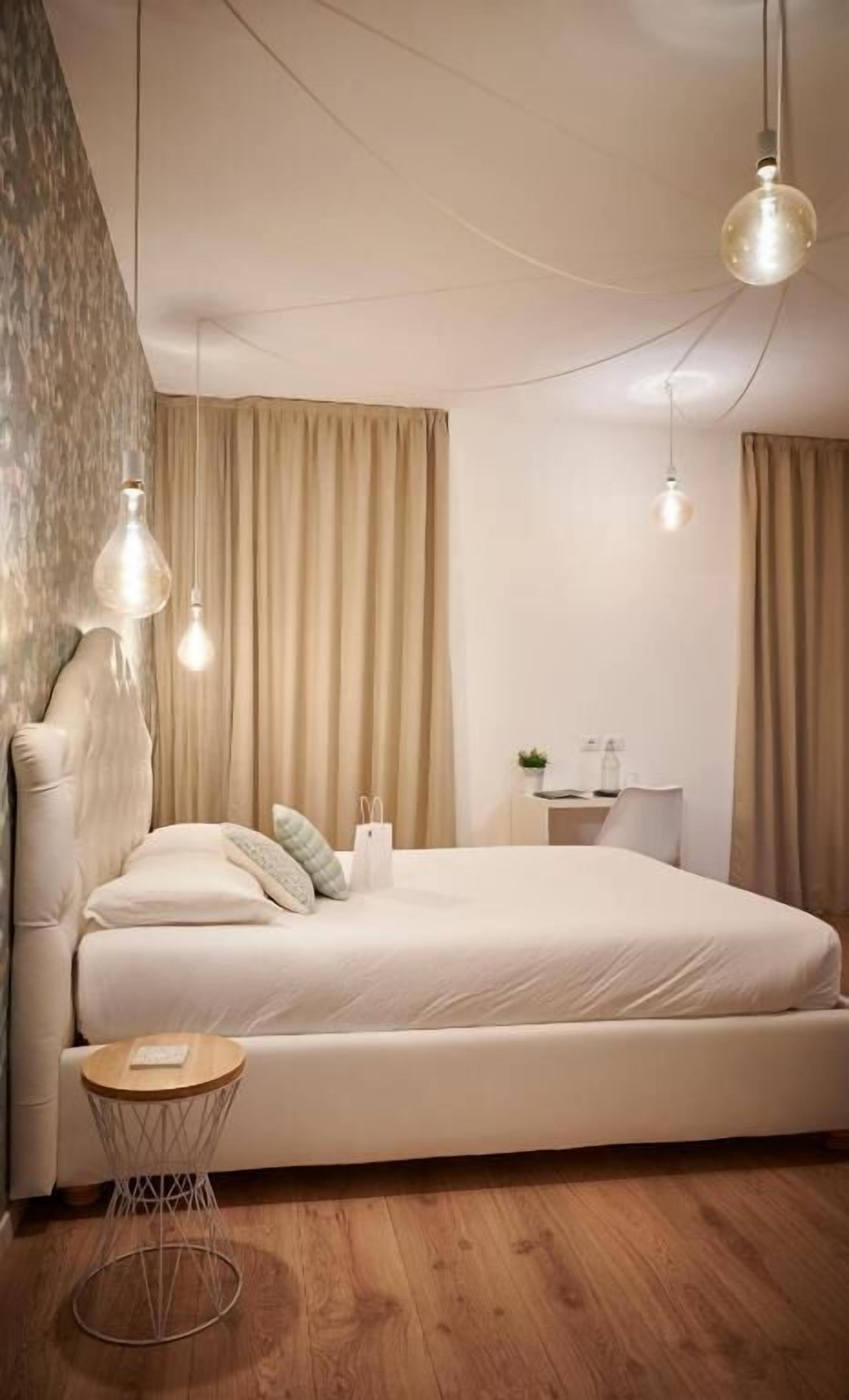 Un dormitorio moderno con una cama grande, una mesita de noche y una pequeña mesa redonda.