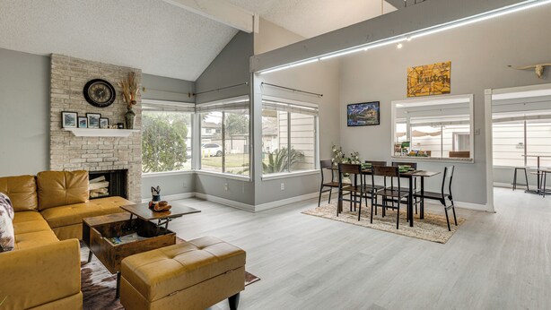 A spacious living room with a fireplace, a dining area, and large windows. - Houston Family Retreat w/ Patio: Near Downtown! (Houston)