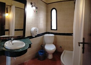 Een badkamer met een wastafel, toilet en douche.