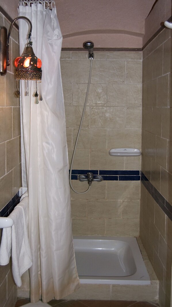 A small, tiled shower area with a white shower curtain, a handheld showerhead, and a white bathtub. - Sharks Bay Umbi Diving Village (Sharm El Sheikh)