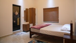 Un dormitorio con cama, armario, espejo y ventana con persianas.