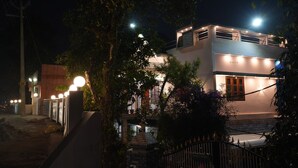 Un edificio de dos pisos con diseño moderno, que cuenta con un balcón y una escalera que conduce al piso superior.
