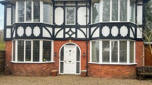 A Tudor-style building with a white and black timber frame, large windows, and a brick facade. - Marton Lodge Apartment (Bridlington)