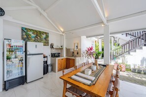 Una cocina amplia con comedor, refrigerador, microondas y pileta.