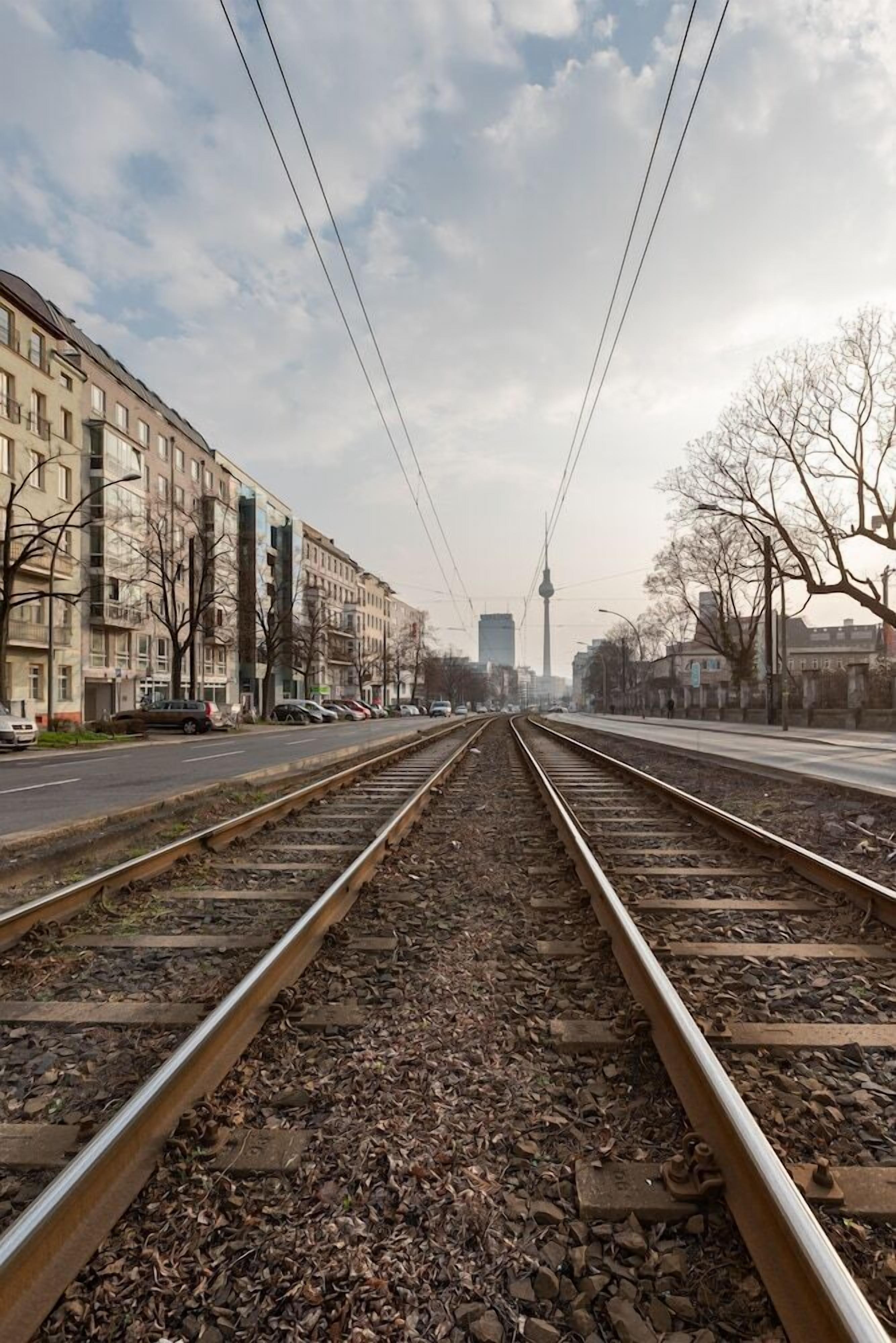 A railway track with a view of buildings and a tower in the distance.