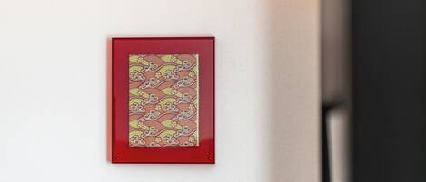 A framed artwork with a traditional pattern on a wall.