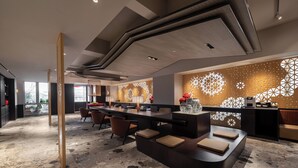 A modern hotel lobby with a long reception desk, seating area, and decorative wall panels. - SSAW Garden Hotel Chengdu - Chunxi Road Taikoo Li Branch (Chengdu)