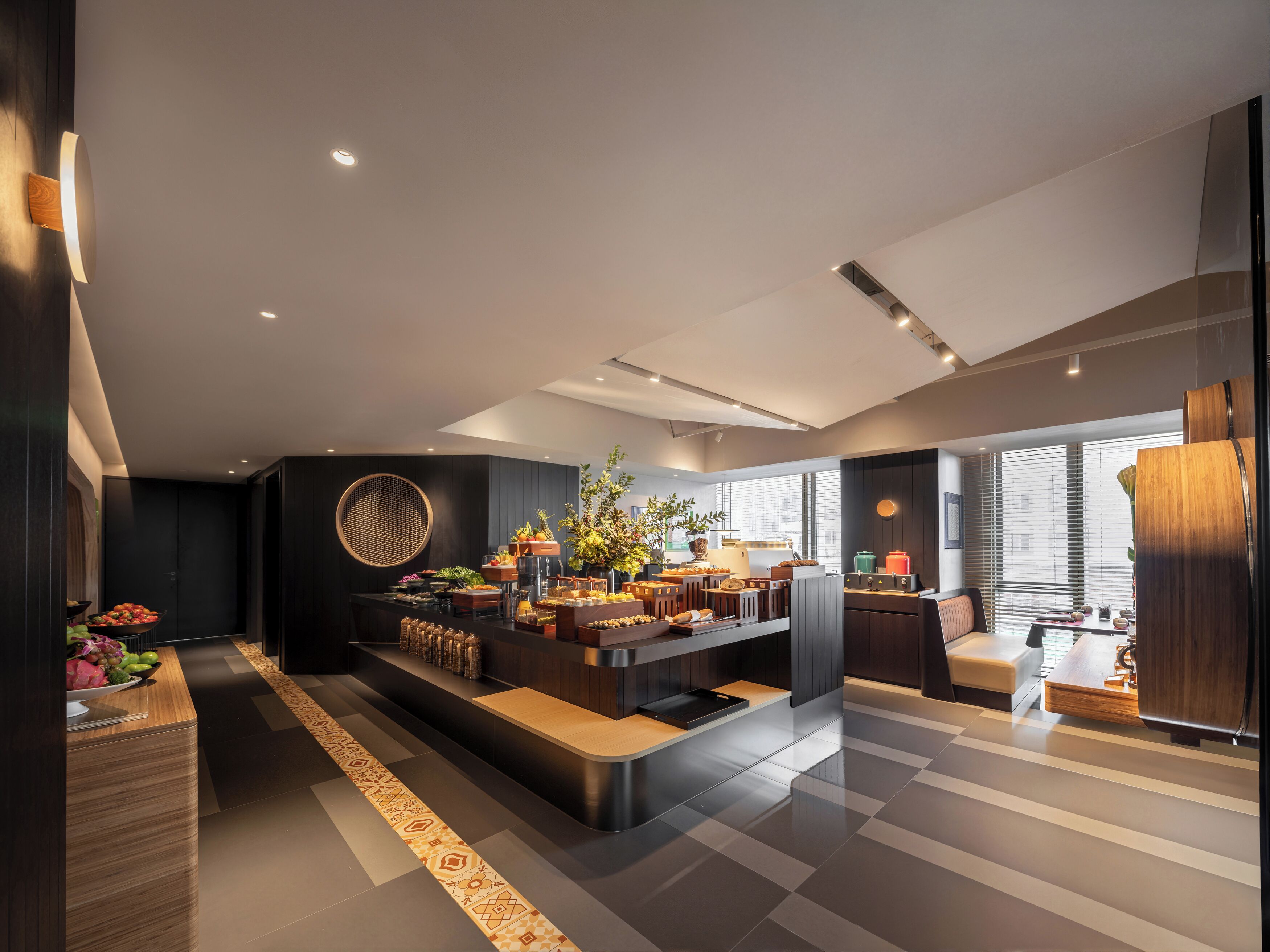 A modern living room with a central coffee table, seating area, and a large window providing natural light.