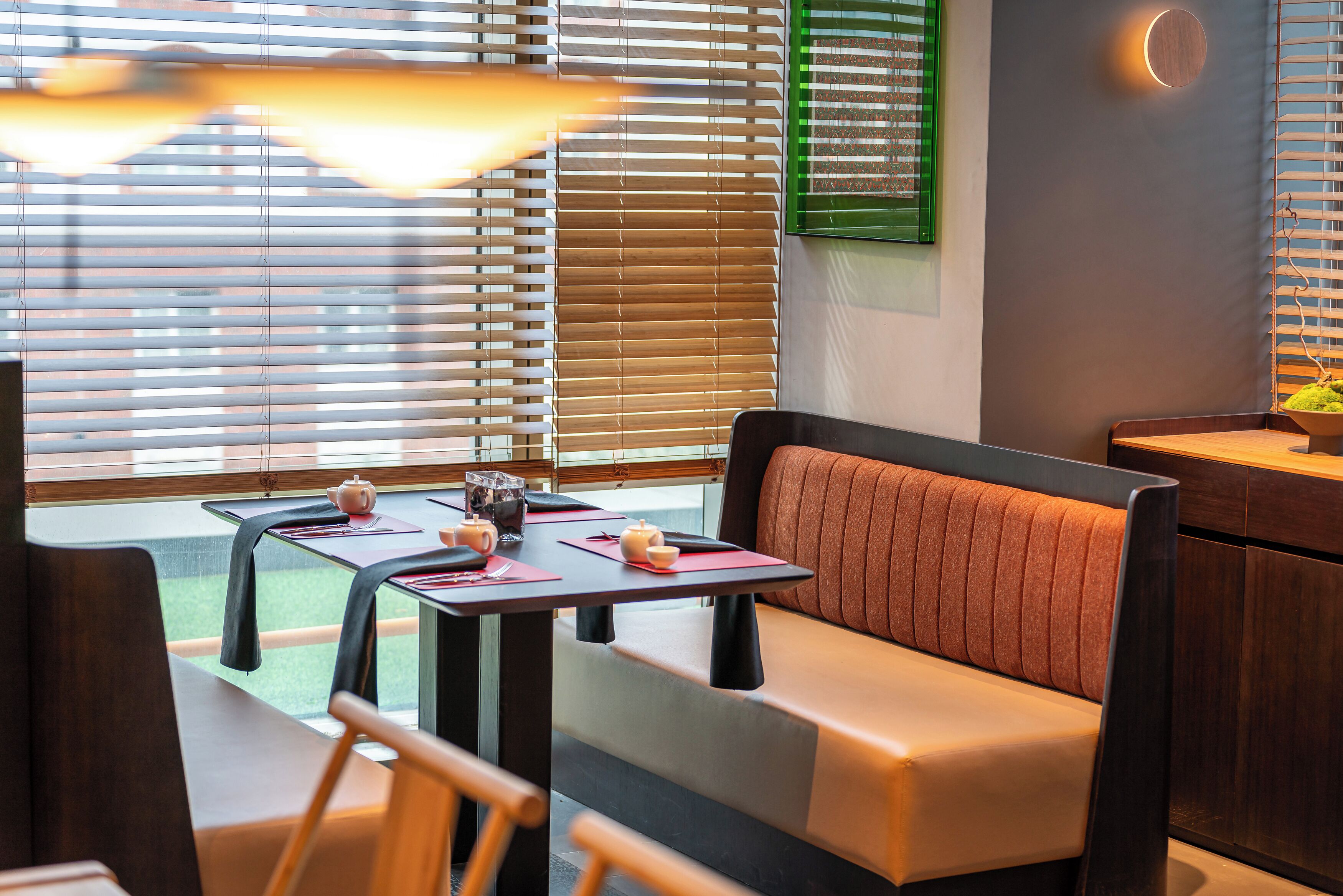A modern interior with a seating area, tables, and a wall-mounted light fixture.