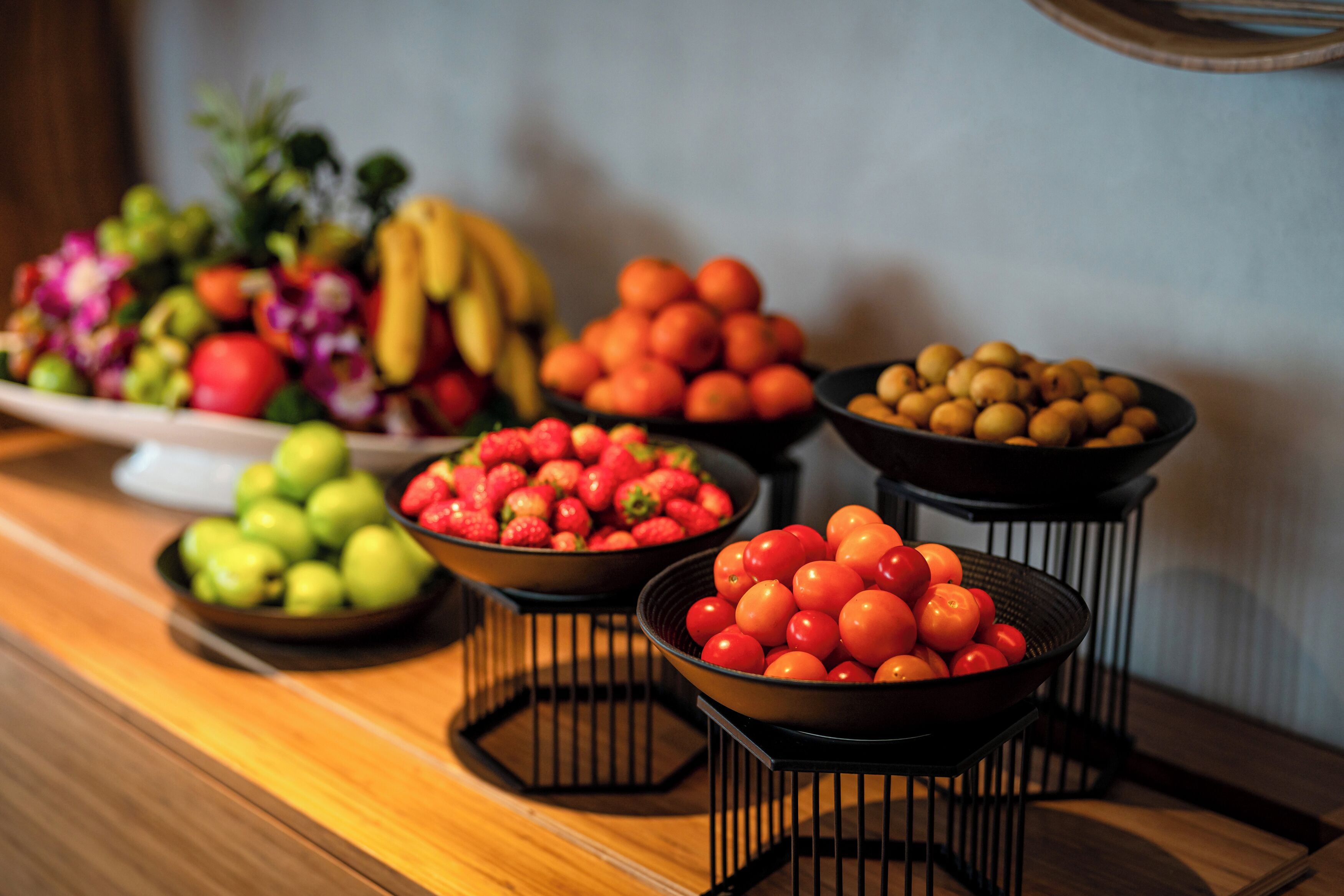 Una mesa de madera con diferentes recipientes de frutas y verduras.