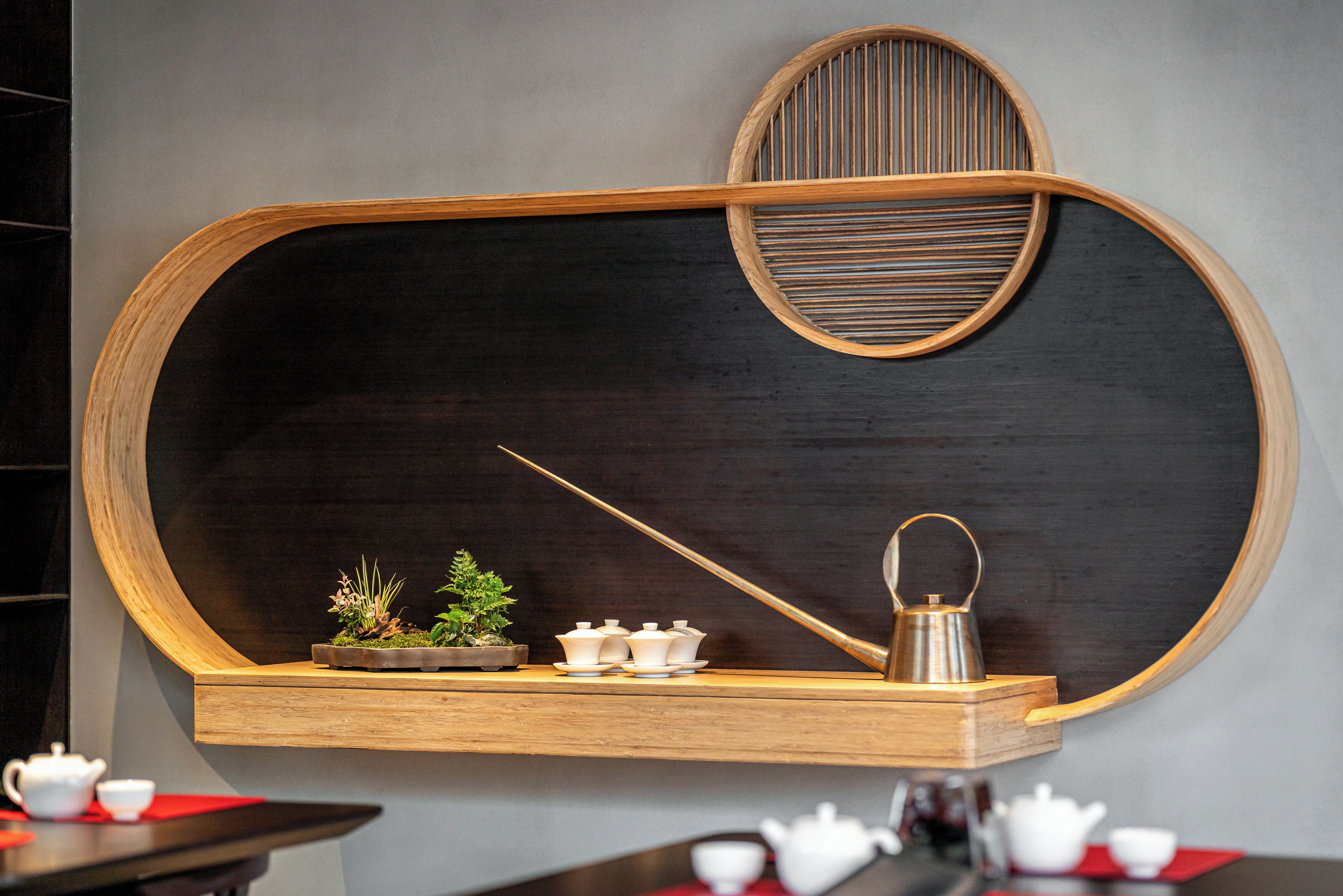 A wall-mounted wooden shelf with a blackboard, a teapot, and a small potted plant.