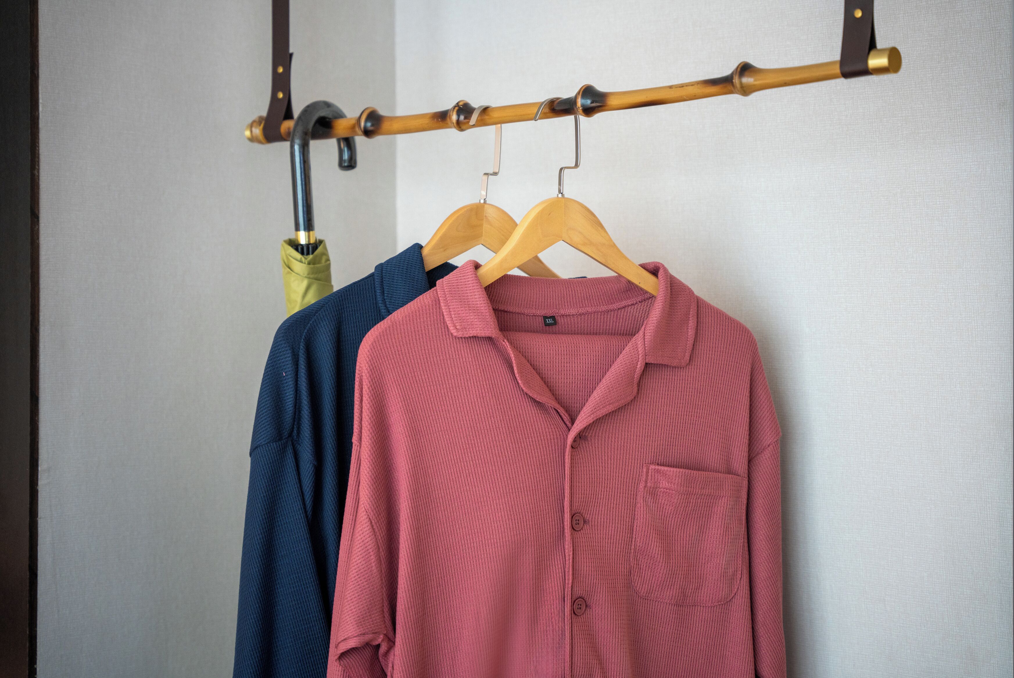 Un perchero con una camisa rosa y una camisa azul colgadas.