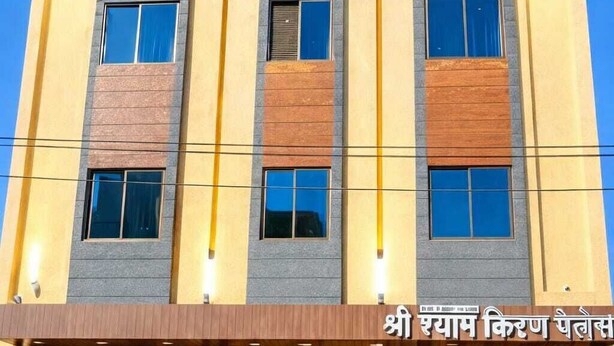 A multi-story hotel with a modern facade, featuring a mix of brick and plaster textures. - Shree Shyam Kiran Palace (Danta Ramgarh)