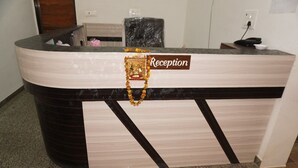 A reception desk with a 'Reception' sign, a decorative garland, and a telephone. - Shree Shyam Kiran Palace (Danta Ramgarh)