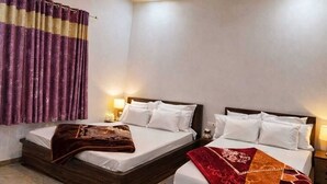 A hotel room with two beds, a ceiling fan, and a modern design. - Shree Shyam Kiran Palace (Danta Ramgarh)